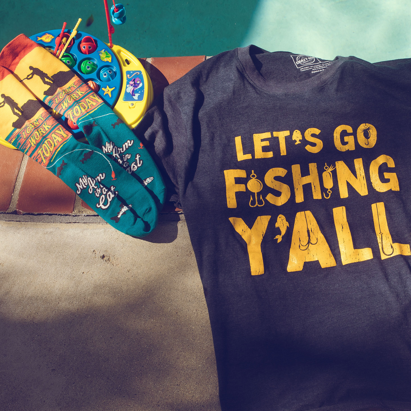 Let's go fishing y'all printed shirt next to I can't work today printed socks 